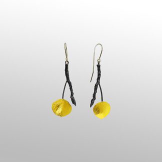 A pair of yellow earrings hanging from black wires.