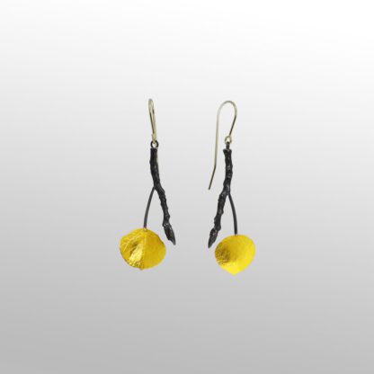 A pair of yellow earrings hanging from black wires.