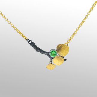 A necklace with two bananas and a green stone.