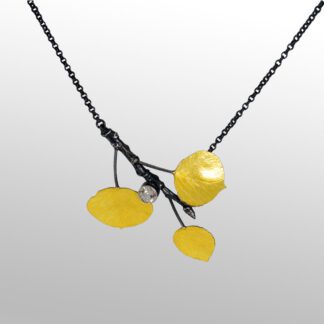 A yellow necklace with three leaves on it.