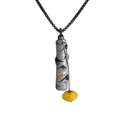 A silver necklace with a yellow charm hanging from it.