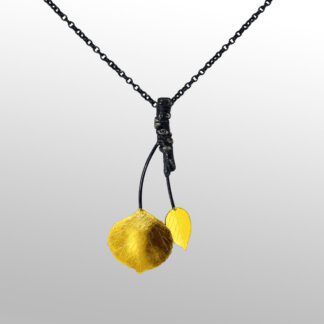 A black chain with a yellow cherry on it.