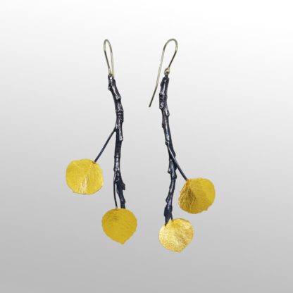 A pair of earrings with yellow leaves hanging from them.