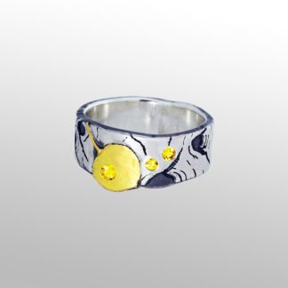 A silver ring with yellow smiley face on it.